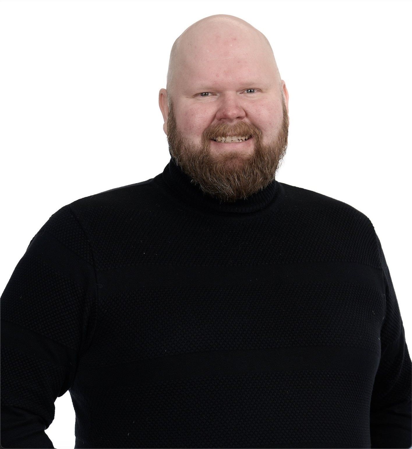 Antti Brunni smiling in a black turtleneck against a white background.
