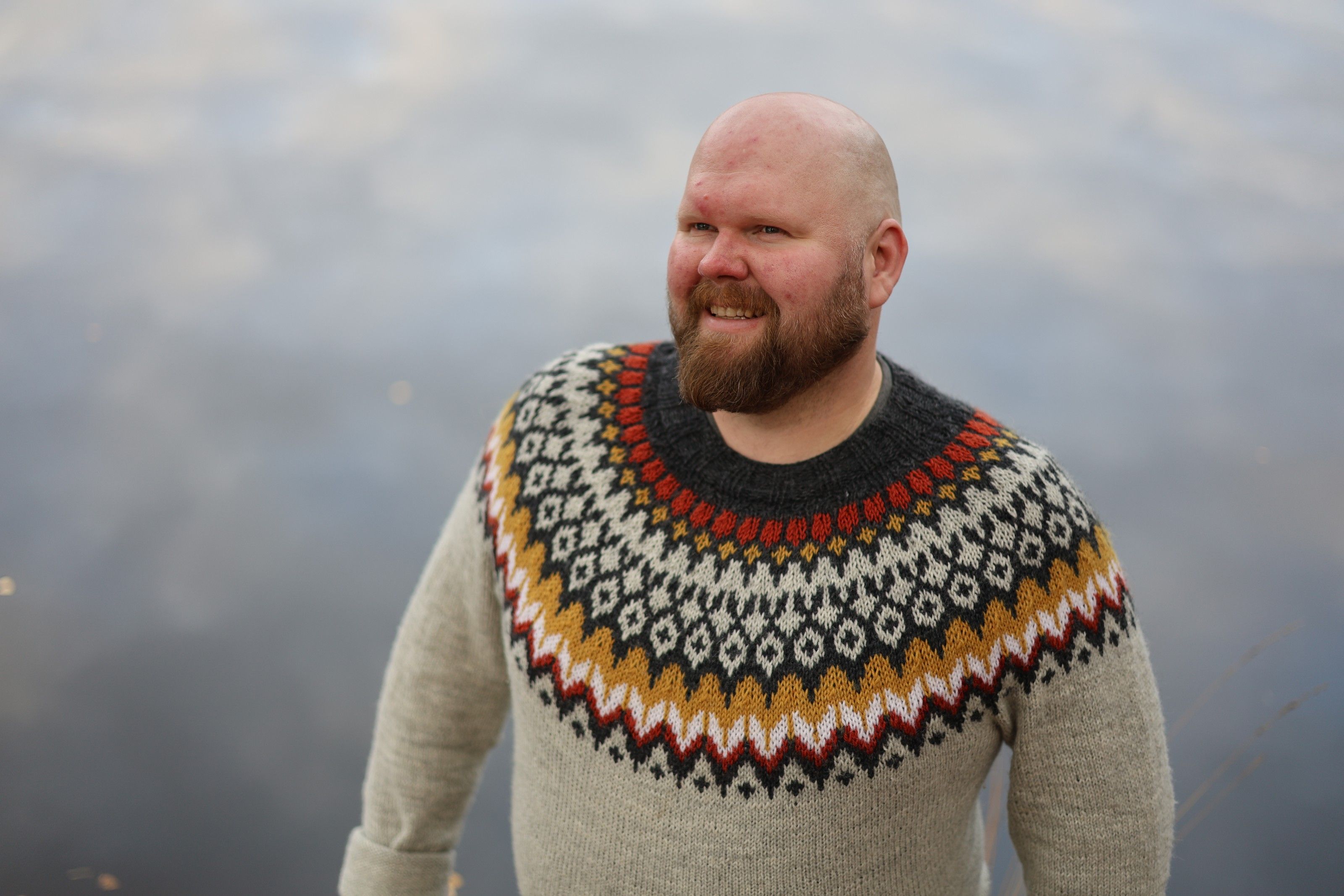 Antti Brunni in a patterned wool sweater by the water.
